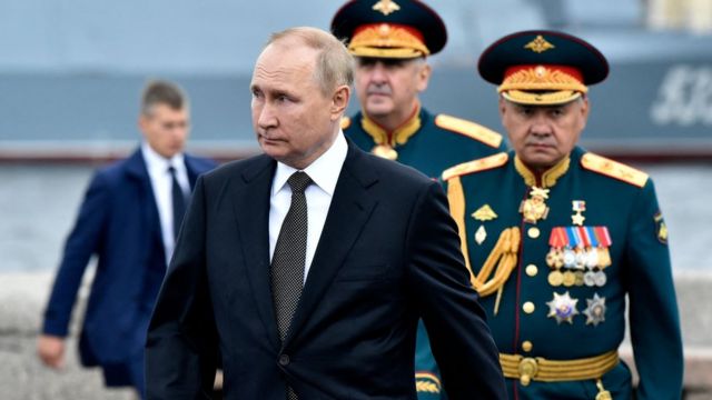 Tổng thống Nga Vladimir Putin (L), đứng bên Bộ trưởng Quốc phòng Nga Sergei Shoigu (R), đi bộ khi ông tham gia cuộc diễu hành hải quân chính đánh dấu Ngày Hải quân Nga, tại St.Petersburg vào ngày 31 tháng 7 năm 2022.