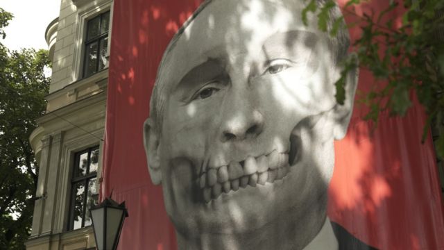 Một bức tranh tường mô tả một hộp sọ với các đặc điểm của Tổng thống Nga Vladimir Putin được trưng bày đối diện Đại sứ quán Nga ở thủ đô Riga của Latvia.